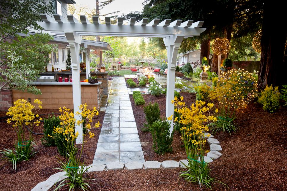 Backyard Garden With White Trellis Over Pathway to Patio | HGTV