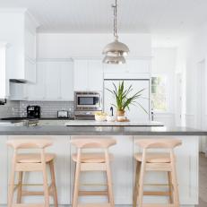 White and Gray Open Plan Kitchen With Wood Barstools