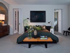 A stylish master bedroom that features a black platform bed. 