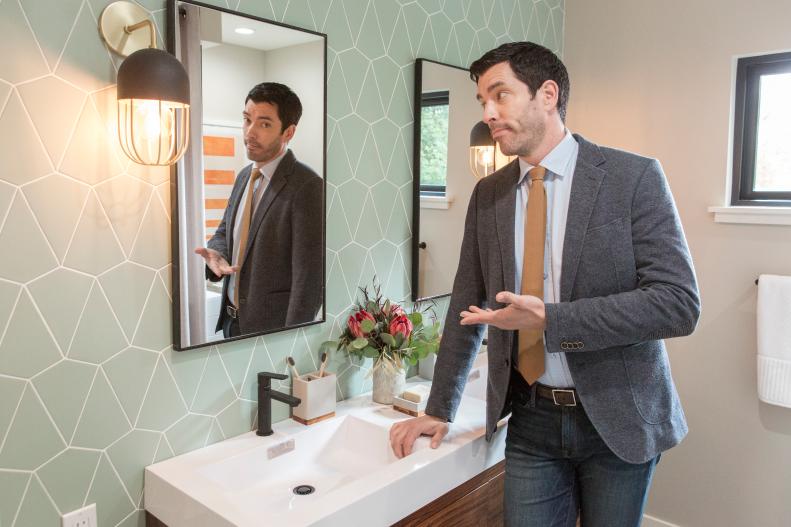 Drew Scott in the renovated guest bathroom, which features striking wall tiles, as seen on Brother vs. Brother.