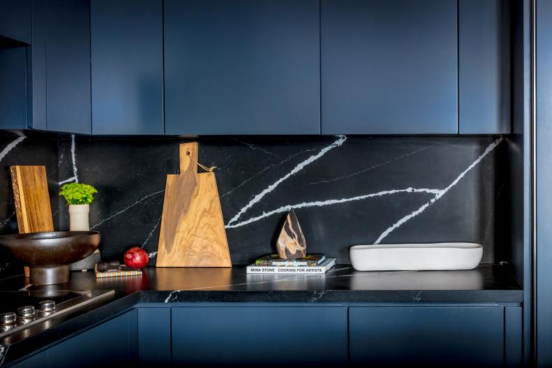 modern blue kitchen with black marble backsplash