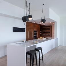 Modern Kitchen With White Work Island And Walnut Cabinets