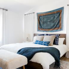 Modern White Master Bedroom With Wood Headboard and Blue Accents