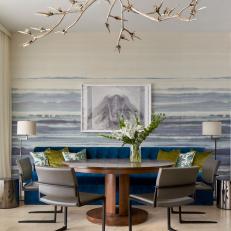 Modern Dining Room With Blue Upholstered Banquette And Accent Wall
