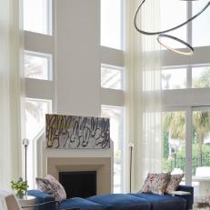 Contemporary White Living Room With Blue Upholstered Sofa And Modern Midcentury Modern Chair