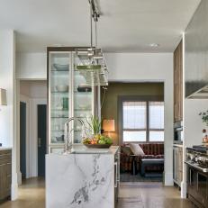 Modern Kitchen With Built In Glass Display Cabinet And Marble Work Island With Glass Task Pendant