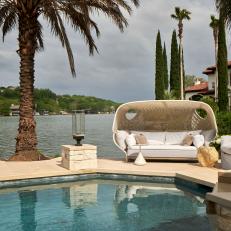 Lakeside Pool Retreat With Natural Stone Accents And White Upholstered Sofa And Armchair