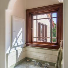 Traditional White Bath With Marble Topped Sink And Spanish Colonial Window Details