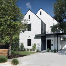 Modern White Farmhouse With Dormer Roof And Black Accent Wall And Covered Entry