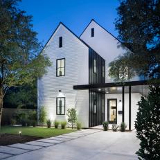 Modern White Farmhouse Exterior With Dormer Roof And Black Metal Accent Wall And Covered Entry