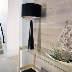 Modern Foyer With Wood Accent Wall And Sculpture With Black Lamp And Console Table