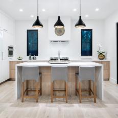 Modern White Kitchen With Work Island And Black Pendant Lights