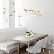 Modern White Dining Room With Built In Banquette And Brass And Glass Chandelier