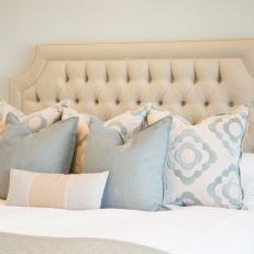 Traditional Master Bedroom With Neutral Tufted Headboard And Soft Blue Accent Pillows