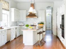 Modern White Kitchen With Copper Vent Hood and Marble Backsplash