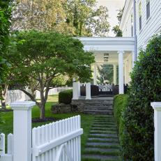 Classic White Colonial Side Porch With Seating Area and Flagstone Path