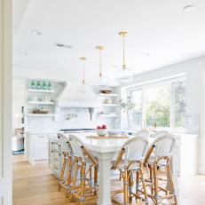 Contemporary White Kitchen With Work Island With Bar Stool Seating And Glass Pendants