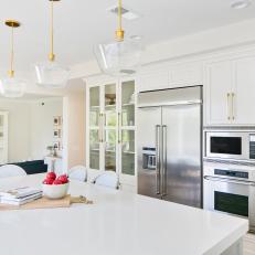 Contemporary White Kitchen With Work Island And Modern Pendant Lights
