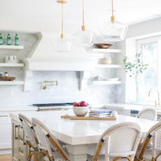 Contemporary White Kitchen With Glass Pendants And Marble Tile Accents