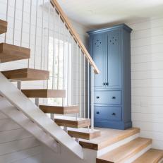 Modern Cottage Foyer Detail With Floating Stairs And Blue Armoire