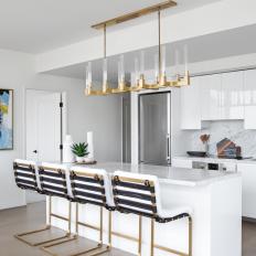 White Modern Kitchen With Brass Barstools