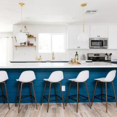 Blue and White Open Plan Kitchen With White Barstools