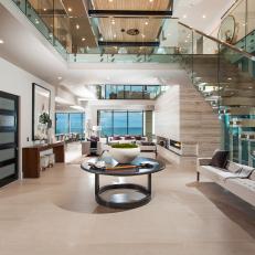 Modern Foyer With Glass Staircase And Railings And Contemporary Furnishings