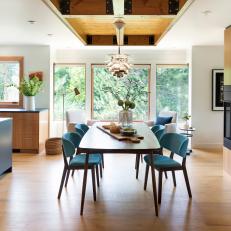 Open Concept Kitchen And Dining Room With Midcentury Modern Furnishings And Gas Fireplace
