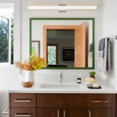 Modern White Bathroom With Single Sink Walnut Vanity And Green Framed Mirror