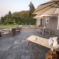 Backyard Lounge With Concrete Pavers And Gas Fire Pit With Wicker Seating And Chaise