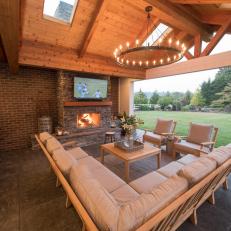 Covered Patio Outdoor Living Room With Upholstered Seating And Stone Fireplace With Built In TV