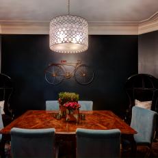 Eclectic Dining Room Featuring Black Walls, Black Balloon Chairs, Traditional Wood Dining Table and Blue Velvet Chairs 