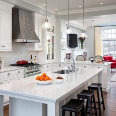 Traditional White Kitchen With Marble Topped Work Island And Bar Stool Seating