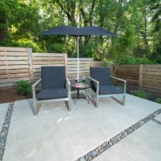 Backyard Sitting Area With Concrete Pavers And Modern Wood Fence