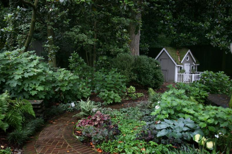 Heuchera and hosta and the playhouse in the distance create a magical ambiance in this Atlanta garden.