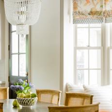 Traditional Dining Detail With Crystal Chandelier And Upholstered Window Seat