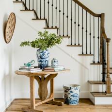 Traditional Wood And Wrought Iron Staircase With Antique Side Table