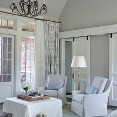White Master Bedroom Sitting Area With Upholstered Furnishings And Iron Chandelier