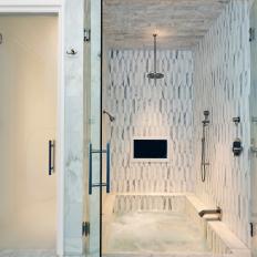 Glass Doors Mark Entrance to Marble Shower