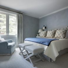 Gray Bedroom With X Benches and Bed With Padded Headboard