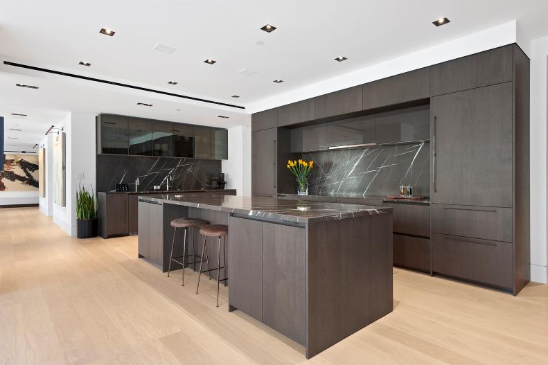 Modern Kitchen Has Dark Brown Cabinets, Island and Stone Backsplash