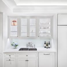 Traditional Kitchen With White Glass Front Cabinets And Subzero Refrigerator