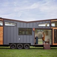 Modern Tiny House With Blue Metal And Natural Wood Siding And Retractable Overhead Door