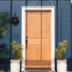 Tropical Blue Home Exterior with Neutral Wood Door 