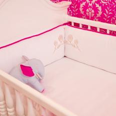 Girl's Nursery Includes White Crib With Floral-Print Cushion