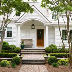 Traditional White Cottage Entrance With Brick Pathway And Crepe Myrtles And Cottage Landscaping