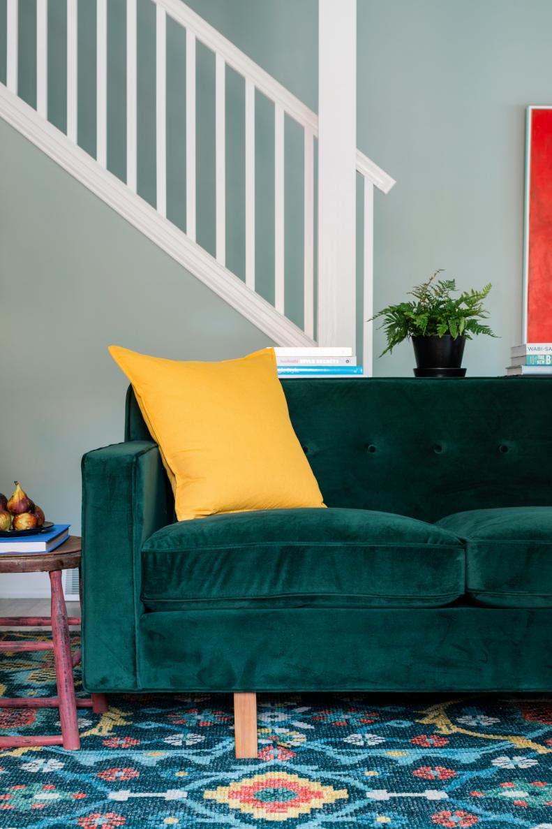 One of designer Brian Patrick Flynn’s favorite design details in the home, the two identical emerald green sofas include a Midcentury Modern style with hardwood box frame construction, plush velvet upholstery, button tufting and tapered wood legs.