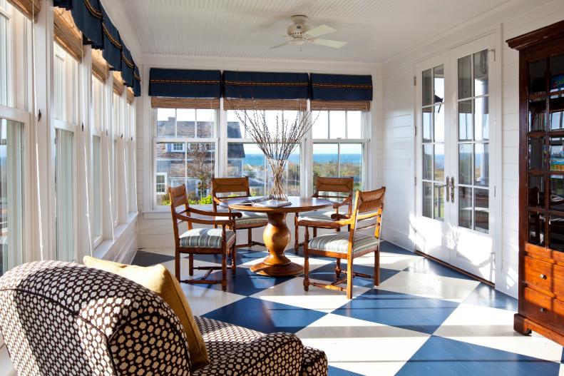 The floor can be a great, unexpected place to add a pop of pattern—like an oversized check. Here, designer Jeannie Balsam of Jeannie Balsam Interiors used this approach to create a fresh, fun look in the sunroom of a second home. “Situated directly off the first floor’s main gathering rooms, this inviting space was inspired by the sun porches of historical nautical homes. The bold floor, woven blinds, and symmetrical blue valances offer maximum energy and draw you into the space without distracting you from the main attraction: the incredible water views.”