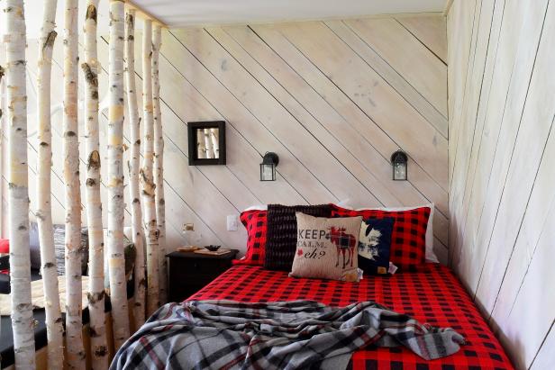 To give a cabin in the Canadian woods a cozy feel, designer Meghan Price of Maple & Plum turned to natural textures and classic rustic patterns. “Nothing feels more like a cabin retreat in the Canadian wilderness than buffalo plaid,” she says. “The bold black and red check pops off of the neutral white-wash wood, birch trees, plywood furniture. And don’t be afraid to mix plaids. By layering the gray wool plaid blanket on the buffalo plaid, we added another level of depth and interest to the space.”
