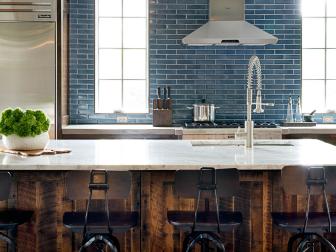 “The goal for the look and feel of this house was all about the use of materials and finishes,” say designers Adrianne Bugg and Brandeis Short of Pillar & Peacock. “Our clients wanted a clean-lined, industrial modern home with warm touches. We used reclaimed wood on the floors and the island. The island has a marble countertop to add a luxe element to the space and complement the concrete tops used on the perimeter of the kitchen. The blue tile adds a color backdrop while framing the windows and complementing the metal counter stools.”